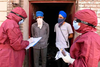 Medical staff wearing protective gears visit a residential area to screen residents in the wake of COVID-19 coronavirus outbreak, during a government-imposed nationwide lockdown as a preventive measure against the COVID-19 coronavirus in Amritsar.  AFP