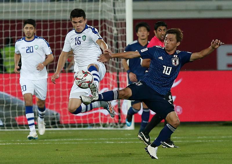 Nakajima fights for the ball against Uzbekistan's Azizbek Turgunboev, left. AP Photo