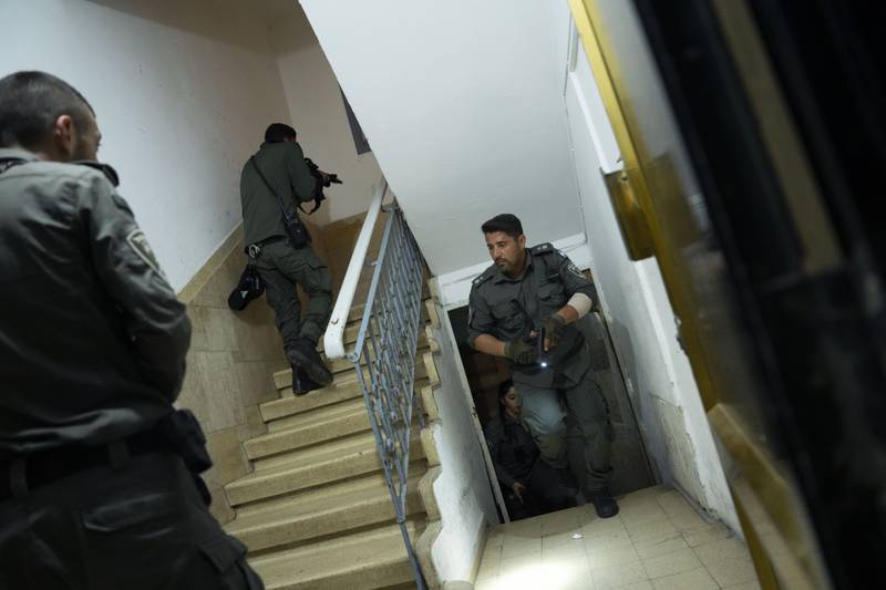 Israeli police officers run upstairs as they search for a suspect in a shooting attack in Tel Aviv. AP Photo