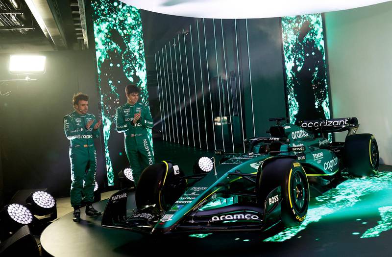 Aston Martin drivers Fernando Alonso and Lance Stroll next to the new AMR23 car for the 2023 season, during its unveiling at their headquarters in Silverstone. AFP
