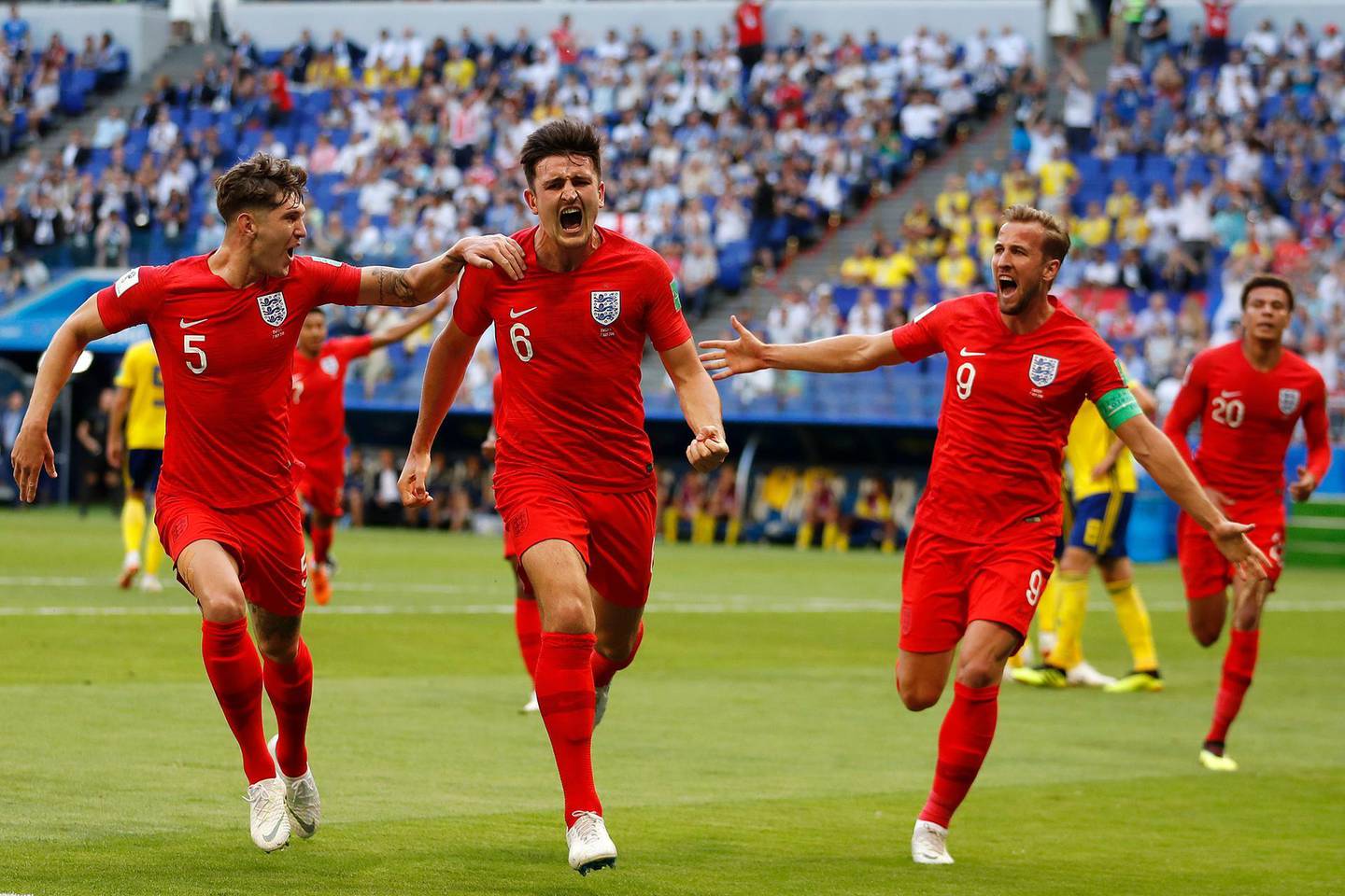 England's Harry Maguire, center, celebrates with his team mates after scoring his side opening goal during the quarterfinal match between Sweden and England at the 2018 soccer World Cup in the Samara Arena, in Samara, Russia, Saturday, July 7, 2018. (AP Photo/Francisco Seco)