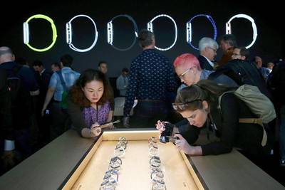 Attendees record a display of the new Apple Watch during an Apple special event at the Flint Center for the Performing Arts on September 9, 2014 in Cupertino, California. Apple unveiled the Apple Watch wearable tech and two new iPhones, the iPhone 6 and iPhone 6 Plus. Justin Sullivan / Getty Images / AFP