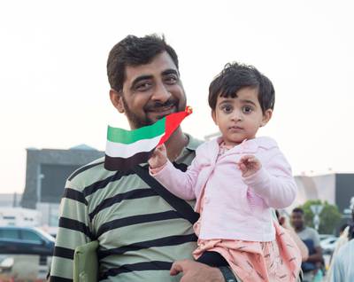 Abu Dhabi, United Arab Emirates - A father and daughter celebrating the UAE National day at Abu Dhabi Corniche, Breakwater.  Leslie Pableo for The National