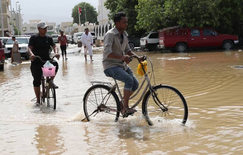 People make their way through Fujairah's floodwaters. EPA
