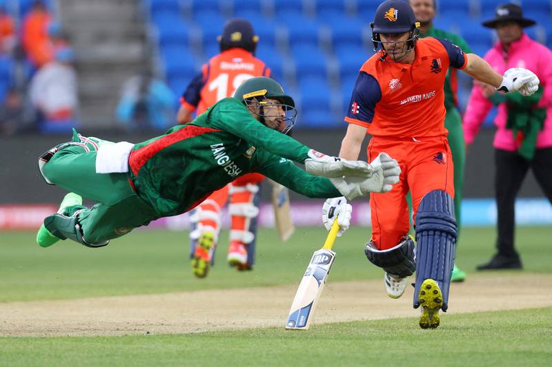 Bangladesh's Nurul Hasan dives to field the ball as Netherlands' Colin Ackermann run through. AFP