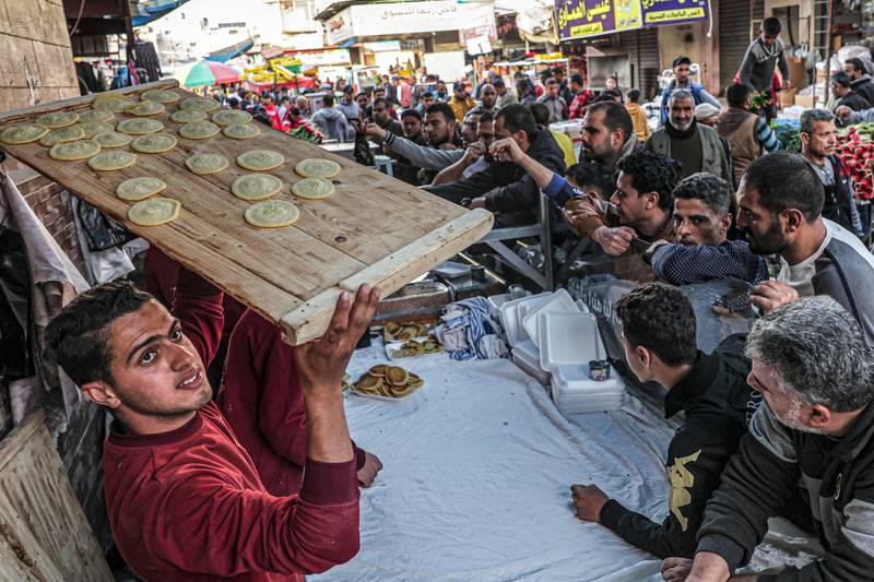 A Palestinian man carries a tray of qatayef, traditional Arabic dumplings, in Rafah, southern Gaza. AFP