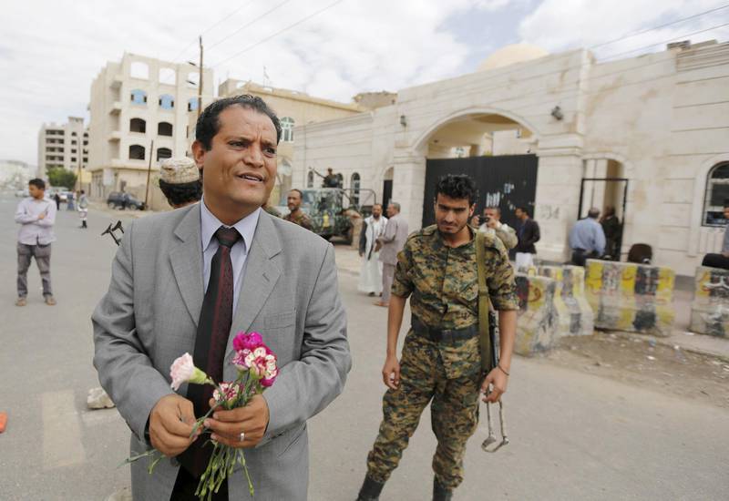 Abdullah al-Olufi, the spokesperson for the Baha'i community in Yemen, holds flowers as he stands outside a state security court during a hearing in the case of a Baha'i man charged with seeking to establish a base for the community in Yemen, in the country's capital Sanaa April 3, 2016. REUTERS/Khaled Abdullah - GF10000369842