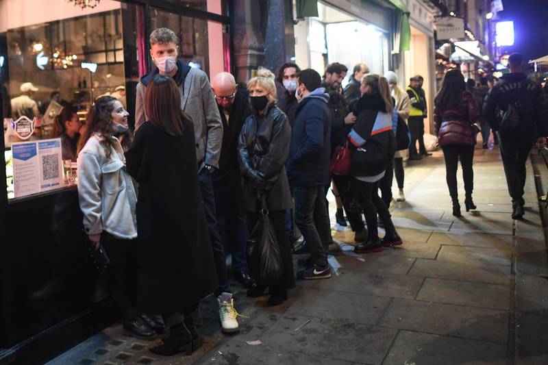 People are seen queuing outside a restaurant in Soho. Getty Images