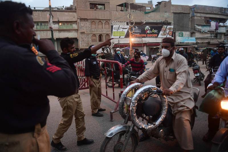 Policemen stop commuters at a checkpoint after authorities imposed an evening lockdown to curb the spread of Covid-19 in Karachi, Pakistan. AFP