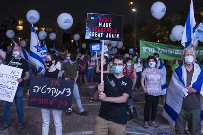 Israelis hold signs as they protest against the Israeli goverment's plan to annex parts of the West Bank in Tel Aviv, Israel. Getty Images