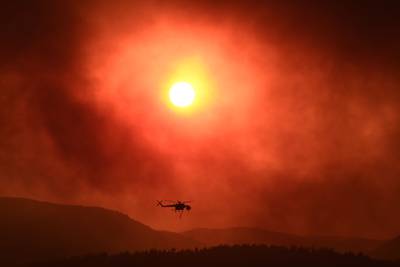 A helicopter flies over a wildfire raging near Alexandroupoli, northern Greece. AFP