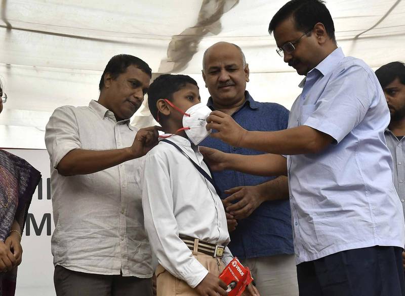 Chief Minister of Delhi Arvind Kejriwal and deputy chief minister Manish Sisodia distribute masks to school students in a Government school in New Delhi, India. EPA