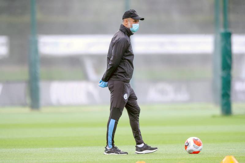 MANCHESTER, ENGLAND - MAY 23: Manchester City's Pep Guardiola wearing a face mask watches his players during training at Manchester City Football Academy on May 23, 2020 in Manchester, England. (Photo by Tom Flathers/Manchester City FC via Getty Images)