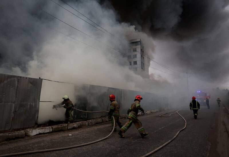 Firefighters at a warehouse that caught fire after shelling in the village of Chaiky in the Kyiv region. Reuters