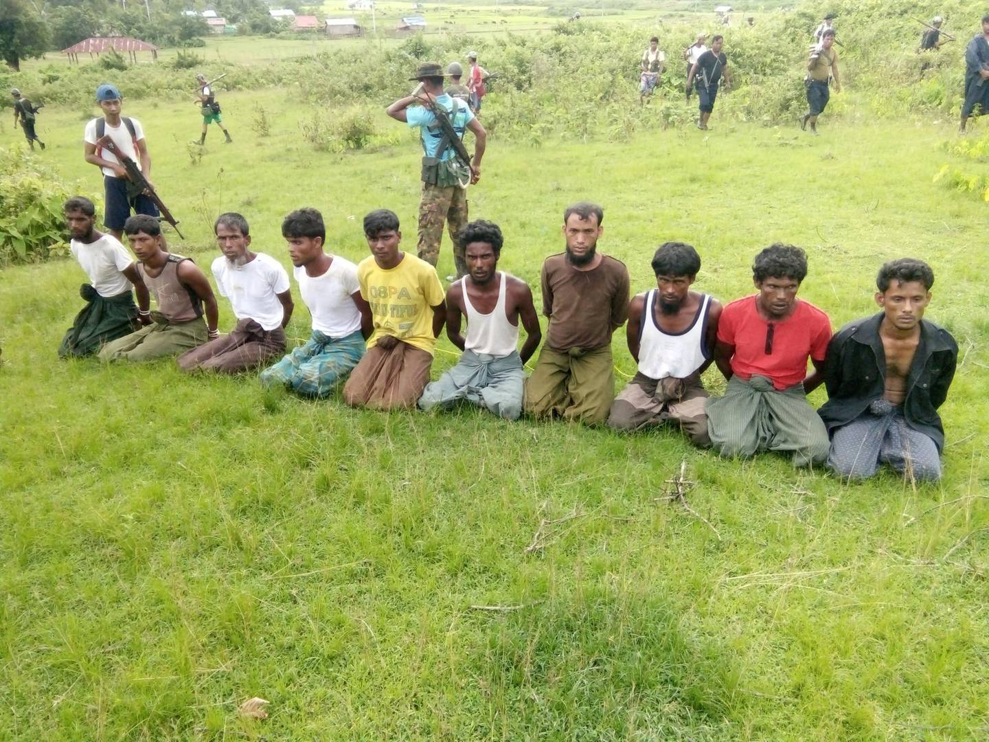 FILE PHOTO: Ten Rohingya Muslim men with their hands bound kneel as members of the Myanmar security forces stand guard in Inn Din village September 2, 2017. To match Special Report MYANMAR-JOURNALISTS/TRIAL    REUTERS/File Photo