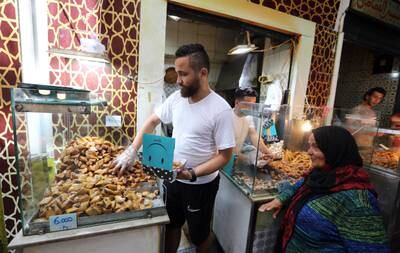 A man sells traditional cakes in his shop at the old city in Tunis, on July 1, 2022.  EPA