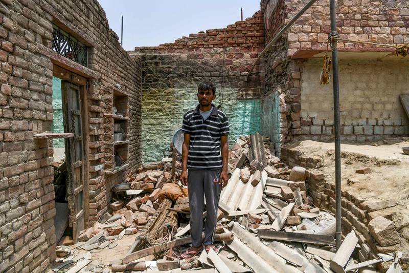 Surrender Kumar poses for a photo where his home stood in Agra. Kumar lost his 10 year old son, Vivek Kumar, and his 5 year old nephew in the storm. Chandan Khanna / AFP