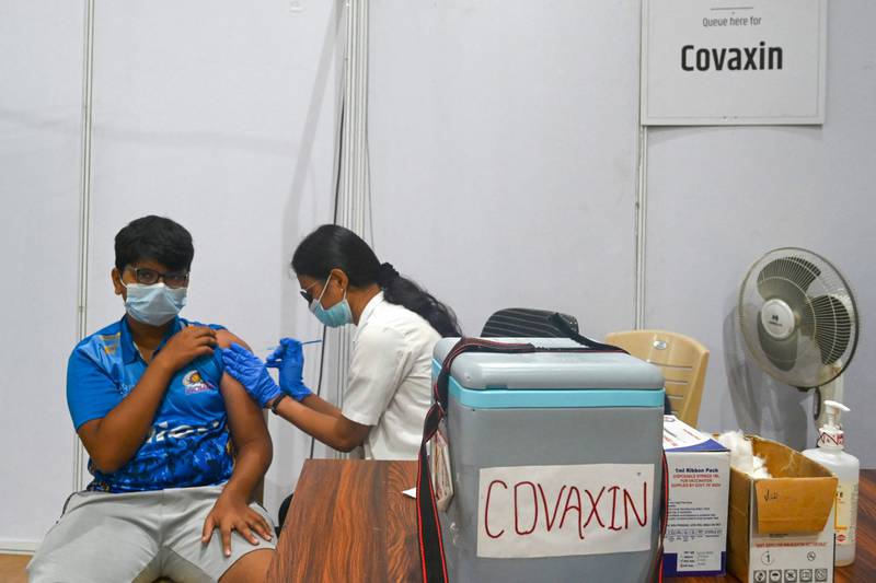 A health worker inoculates a teenage boy with a dose of the Covaxin vaccine in Mumbai. AFP