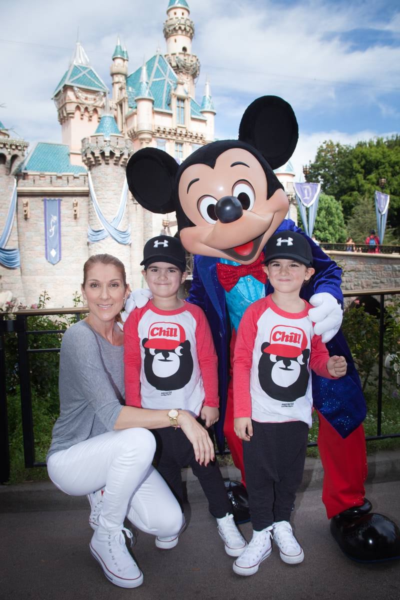 Dion with her twin sons Eddy, left, and Nelson, then aged four, for the boys' birthday with Mickey Mouse at Disneyland park in California in 2016. Getty Images