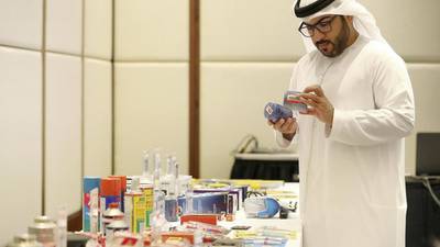 Captain Ahmed Al Kaabi from Abu Dhabi Police views counterfeit products on show during a workshop held by The Legal Group in Abu Dhabi in December 2019. Pawan Singh / The National 