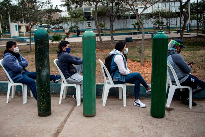 Relatives of Covid-19 patients queue to recharge oxygen cylinders in Villa Maria del Triunfo, in the southern outskirts of Lima, Peru. AFP