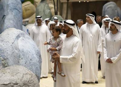 YAS ISLAND, ABU DHABI, UNITED ARAB EMIRATES - July 23, 2018: HH Sheikh Mohamed bin Zayed Al Nahyan, Crown Prince of Abu Dhabi and Deputy Supreme Commander of the UAE Armed Forces  (C) and his granddaughter HH Sheikha Salama bint Diab bin Mohamed bin Zayed Al Nahyan (L), attend the opening of Warner Bros World Abu Dhabi. Seen with HH Sheikh Hamdan bin Mohamed Al Maktoum, Crown Prince of Dubai (R) and HE Khaldoon Khalifa Al Mubarak, CEO and Managing Director Mubadala, Chairman of the Abu Dhabi Executive Affairs Authority and Abu Dhabi Executive Council Member (back). 

( Eissa Al Hammadi for The Crown Prince Court )
---