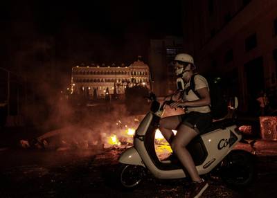 An Anti-government protester on her motorcycle returns where burn tires block the road near the government palace, during a protest against the economic condition, the collapsing Lebanese pound currency and and increasing prices in Beirut. EPA