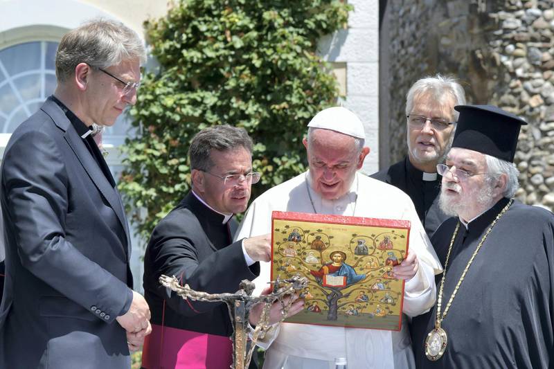 Pope Francis, flanked by Olav Fykse Tveit from Norway, General Secretary of World Council of Churches (WCC) (L) exchanges gifts during a visit to the Ecumenical Institute of Bossey, near Geneva, on June 21, 2018. - Pope Francis visits the World Council of Churches as centrepiece of the ecumenical commemoration of the WCC's 70th anniversary. (Photo by Tiziana FABI / POOL / AFP)