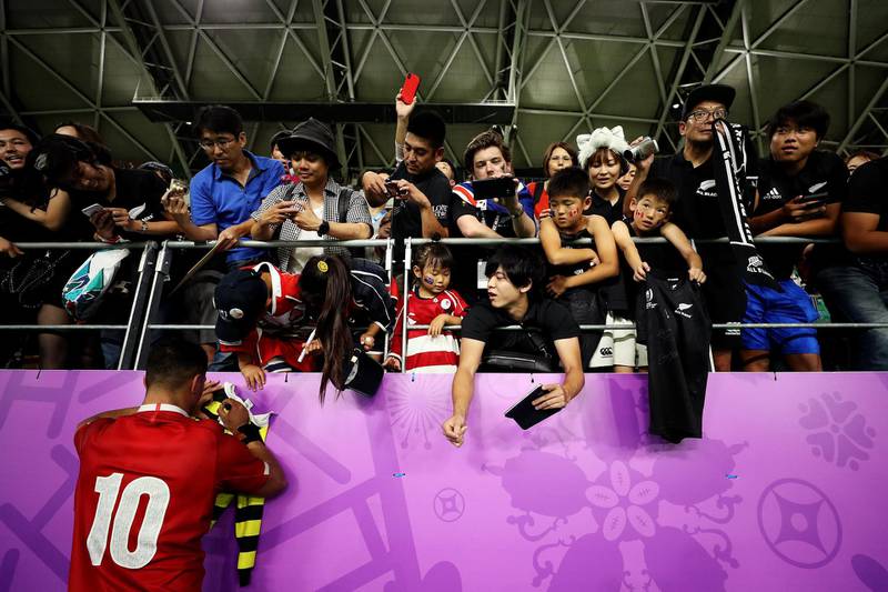 OITA, JAPAN - OCTOBER 02: Richie Mo'unga of New Zealand signs autographs for fans following the Rugby World Cup 2019 Group B game between New Zealand and Canada at Oita Stadium on October 02, 2019 in Oita, Japan. (Photo by Hannah Peters/Getty Images)