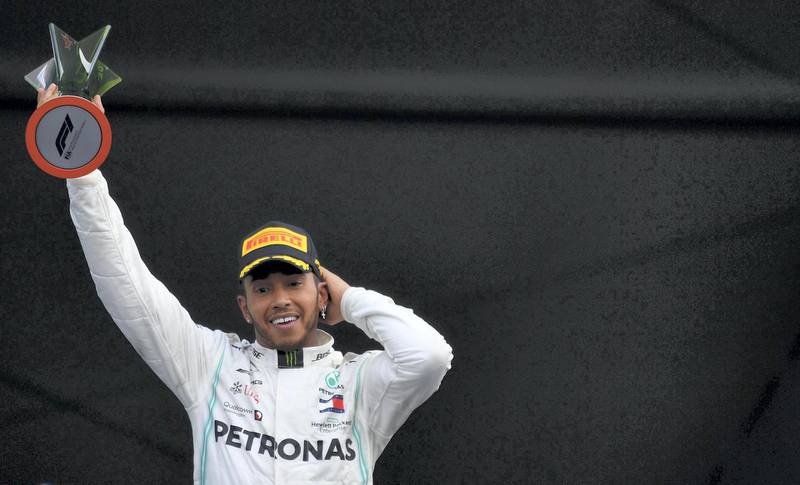 TOPSHOT - Mercedes' British driver Lewis Hamilton celebrates at the podium after winning the F1 Mexico Grand Prix, at the Hermanos Rodriguez racetrack in Mexico City on October 27, 2019. Lewis Hamilton won the Mexican Grand Prix on Sunday, but will have to wait for his sixth world title after Mercedes teammate Valtteri Bottas came home in third. / AFP / PEDRO PARDO
