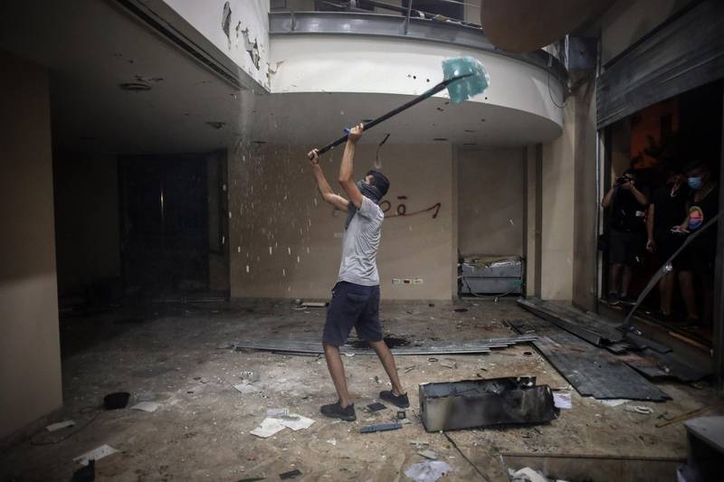 A protester strikes the ceiling inside the Lebanese Banks Association (ABL) headquarters during a demonstration. Bloomberg