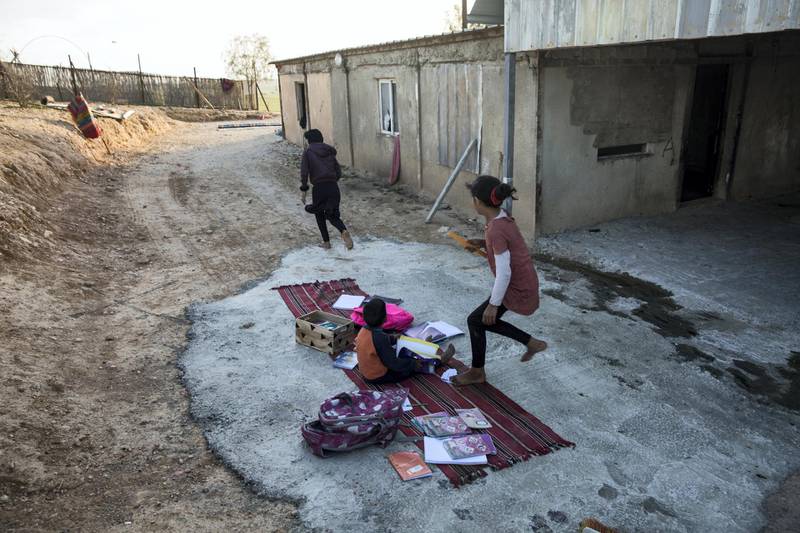 Young Bedouin children doing homework in the yard of their home in the unrecognized village of al-Poraa near the city of Arad in the Negev Desert on February 4,2018. 
There is a plan to build a phosphate mine in the area believed to hold 65 million tons of phosphate  which Israeli's Knesset is scheduled to discuss despite the area is populated by Bedouins who fear it  will cause serious health risks and most likely evict them from their homes. Residents of Arad have also protested against the plan .(Photo by Heidi Levine for The National).
