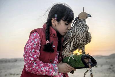 Osha Khaleefa Al Mansoori (7),  she is very much confident and passionate about falcons and falconry as a heritage sport, before release the falcon for the training , she always embrace her falcon at remote Abu Dhabi desert, UAE, Vidhyaa Chandramohan for The National