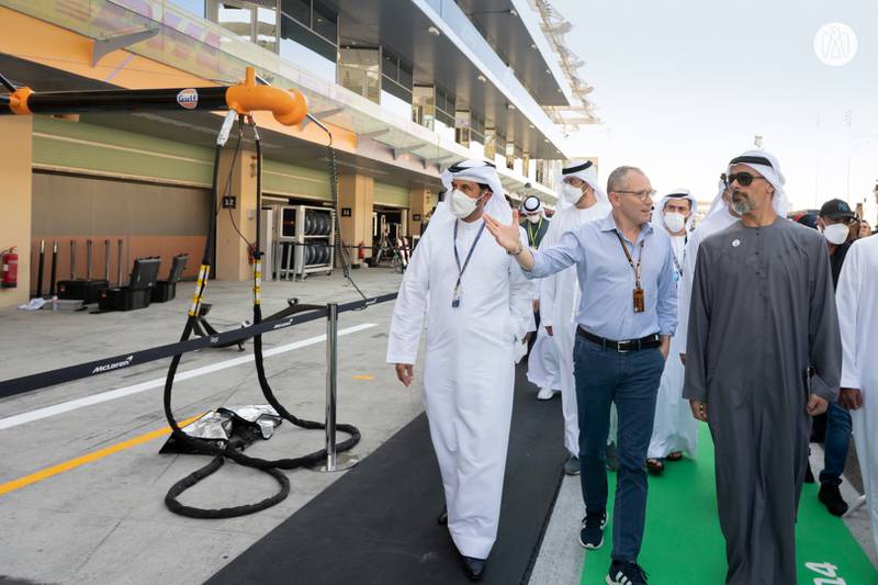 Sheikh Khaled and Stefano Domenicali walk the pit lanes at Yas Island's F1 track.
