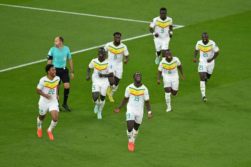 Famara Diedhiou is chased by Senegal teammates after scoring their second goal. Getty
