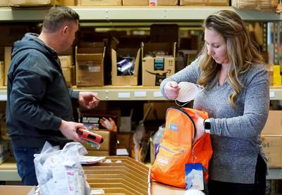 Kristen Curley (right), owner of Nitro-Pak, and an employee, put items into a backpack as part of personal protection and survival equipment kits ordered by customers preparing against novel coronavirus, at Nitro-Pak in Midway, Utah, US. Reuters