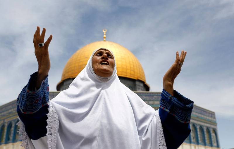 A Palestinian woman prays outside the Dome of the Rock shrine in the Al Aqsa Mosque compound in Jerusalem's Old City. The shrine was built between 685 and 691. AFP