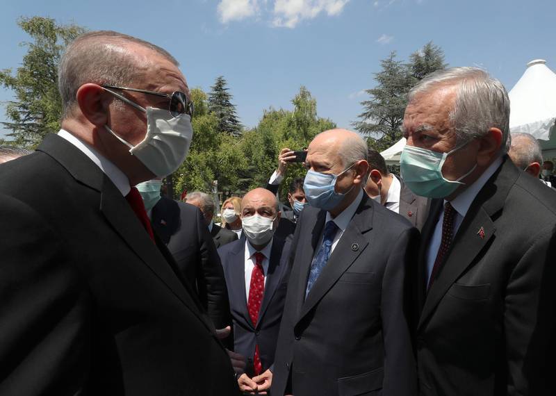 Turkey's President Recep Tayyip Erdogan, left, speaks with Nationalist Movement Party leader Devlet Bahceli, centre, and lawmaker Celal Adan at the parliament for a ceremony, in Ankara, Turkey, Wednesday, July 15, 2020. AP