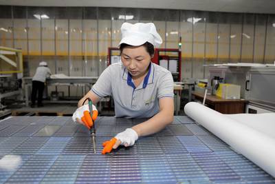 A worker produces solar photovoltaic modules used for solar panels in Huaian city, in eastern China's Jiangsu province. AFP