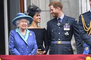 Queen Elizabeth ll, Meghan, Duchess of Sussex and Prince Harry, Duke of Sussex stand on the balcony of Buckingham Palace to view a flypast to mark the centenary of the Royal Air Force on July 10, 2018. Anwar Hussein/WireImage