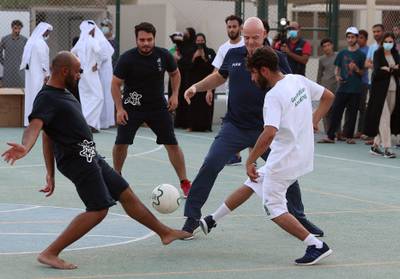 Fifa president Gianni Infantino, centre, plays football with people flown from Afghanistan at Park View Villas, Doha. Accommodation built in Qatar for the 2022 Fifa World Cup  has now assumed a different role from that envisaged by the organising committee - housing Afghan refugees.   AFP