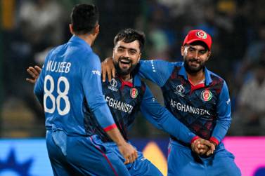 Afghanistan's Rashid Khan (C) celebrates with teammates after taking the wicket of England's Adil Rashid during the 2023 ICC Men's Cricket World Cup one-day international (ODI) match between England and Afghanistan at the Arun Jaitley Stadium in New Delhi on October 15, 2023.  (Photo by Money SHARMA  /  AFP)  /  -- IMAGE RESTRICTED TO EDITORIAL USE - STRICTLY NO COMMERCIAL USE --