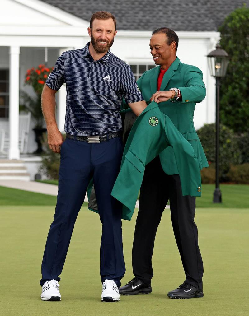 AUGUSTA, GEORGIA - NOVEMBER 15: Dustin Johnson of the United States is awarded the Green Jacket by Masters champion Tiger Woods of the United States during the Green Jacket Ceremony after winning the Masters at Augusta National Golf Club on November 15, 2020 in Augusta, Georgia.   Jamie Squire/Getty Images/AFP
== FOR NEWSPAPERS, INTERNET, TELCOS & TELEVISION USE ONLY ==
