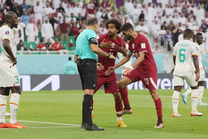 Qatar's Akram Afif and Hassan Al-Haydos appeal for a penalty with Spanish referee Antonio Mateu. AFP
