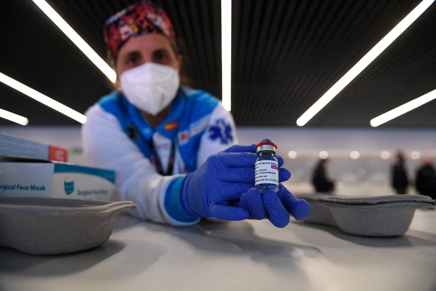 A health worker holds a bottle of the AstraZeneca vaccine against Covid-19 during a mass vaccination campaign by SUMMA 112 (Medical Emergency Services of Madrid) at the Wanda Metropolitan stadium in Madrid on February 25, 2021. So far, some 1.2 million people have been vaccinated in Spain since the start of the immunisation campaign which began just after Christmas with care home residents first in line along with their carers.  / AFP / PIERRE-PHILIPPE MARCOU
