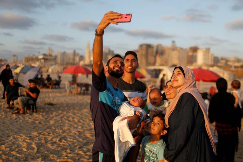 A man takes a selfie with his family on the beach in Gaza City. Reuters