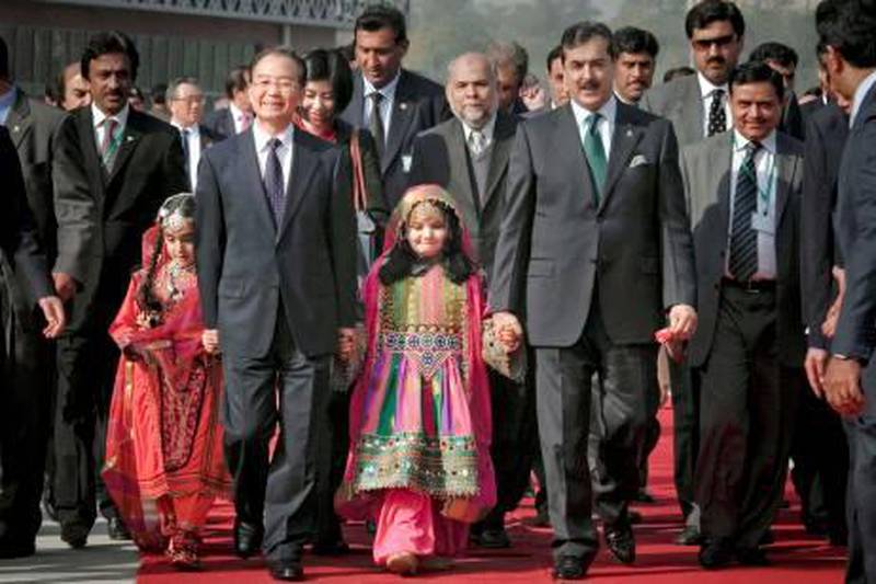 Chinese Premier Wen Jiabao, second from left in foreground, and his Pakistani counterpart Yousuf Raza Gilani, second from right, arrive for a tree planting ceremony in Islamabad, Pakistan, Saturday, Dec. 18, 2010. With 13 agreements already signed, Pakistan and China were expected to ink additional economic deals with billions more, the second day of a rare visit by Wen to this impoverished, conflict-riddon nation. (AP Photo/Anjum Naveed) *** Local Caption ***  XMM101_Pakistan_China.jpg