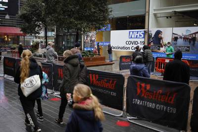 People queue to enter the NHS Covid-19 vaccination centre in Westfield Stratford City shopping centre in east London. AFP