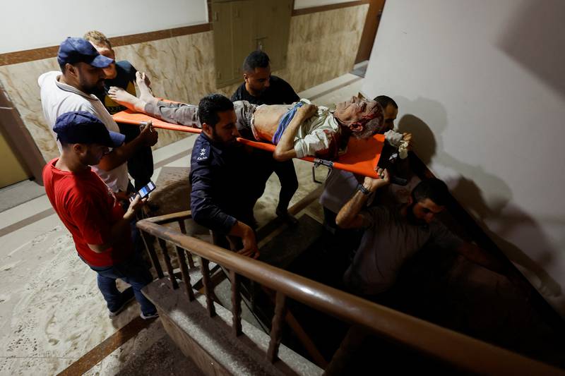 Emergency responders remove an injured person from a building after the air strike. Reuters