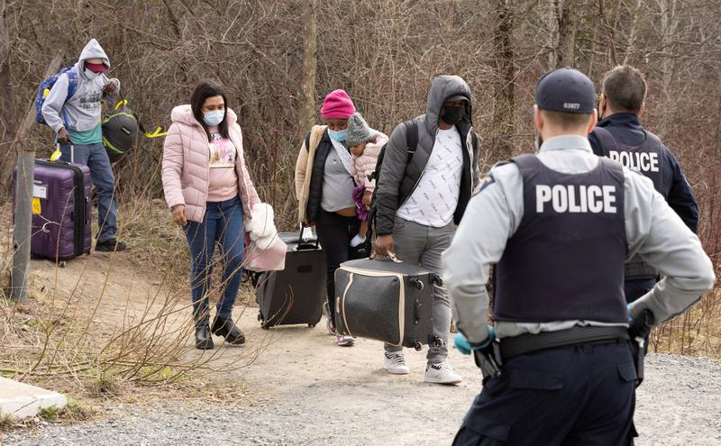 Asylum seekers cross into Canada from the US border near a checkpoint near Hemmingford, Quebec. Reuters